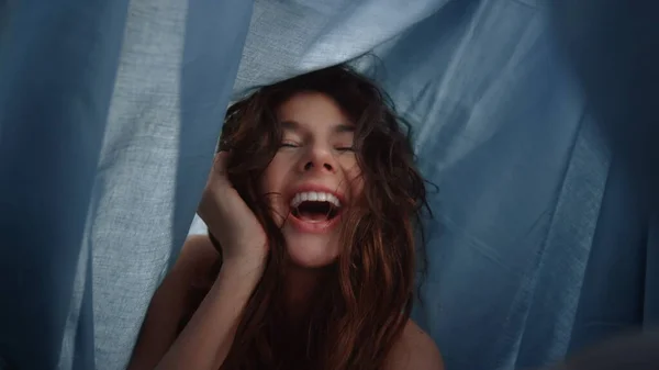 POV chica feliz posando cámara bajo tela drapeada. Mujer riendo por debajo de hoja. —  Fotos de Stock