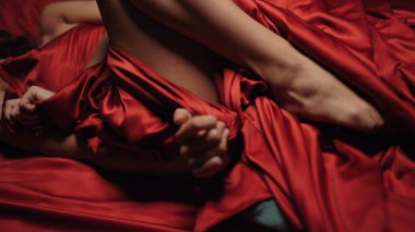 Seksi kadın ipek çarşaf kıvırıyor. Yatak odasında erotik fanteziler kuran çıplak bir kadın..