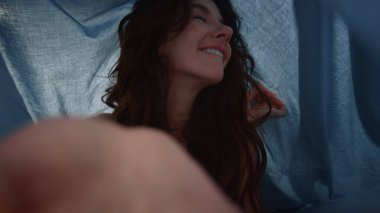 POV 'un neşeli kızı kumaşın altında poz veriyor. Çarşafların altında poz veren kadın.