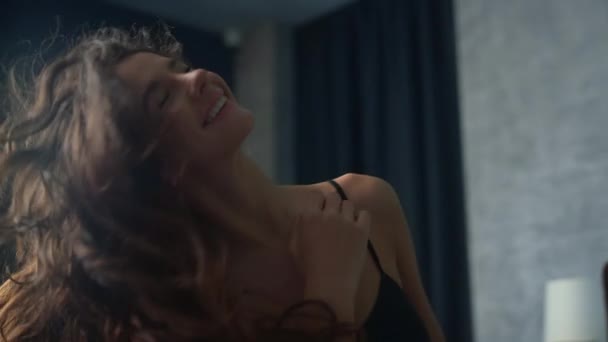 아름다운 여성이 침실에서 머리를 갖고 놀고 있습니다. 집안에서 재미있게 노는 행복 한 여자. — 비디오