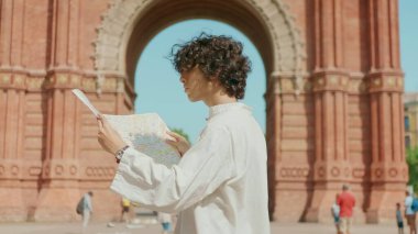 Kapalı alan turisti açık hava haritası arıyor. Haritayla yön arayan genç adam