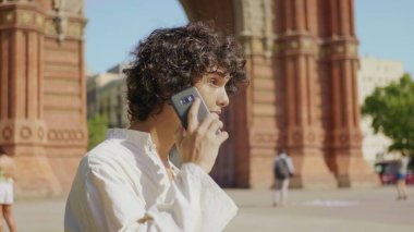 Odaklanmış adam cep telefonunu arıyor. Cep telefonuyla konuşan gülümseyen adamın portresi.