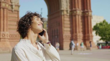 Dışarıda cep telefonuyla konuşan gülümseyen adamın portresi. Mutlu adam bitirme çağrısı