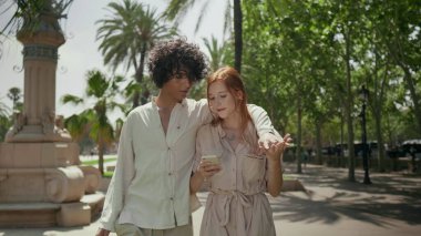 Şehirde gezen romantik bir çift. Odaklanmış çift el ele tutuşuyor