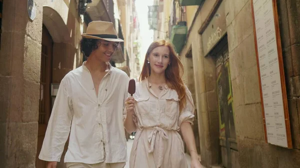 Couple souriant marchant ensemble rue de la vieille ville. Un homme joyeux mangeant de la glace — Photo