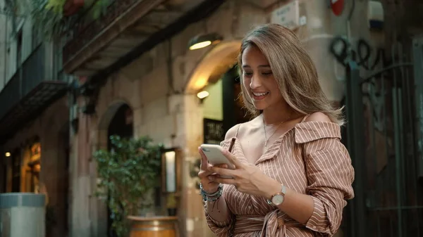 Primer plano mujer feliz buscando teléfono móvil. Señora bonita mensajes de texto teléfono inteligente al aire libre —  Fotos de Stock