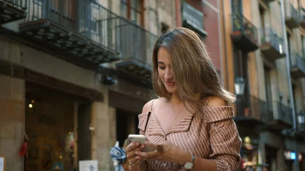 Retrato de jovem procurando telefone celular. Sorrindo menina rolagem smartphone — Fotografia de Stock