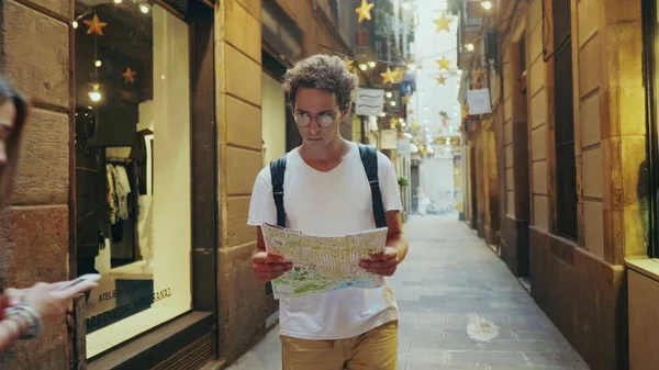 Man tourist searching way with map. Focused student looking correct road