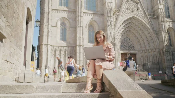 Dışarıda dizüstü bilgisayarlı bir iş kadını oturuyor. Bilgisayardan mesaj alan kız
