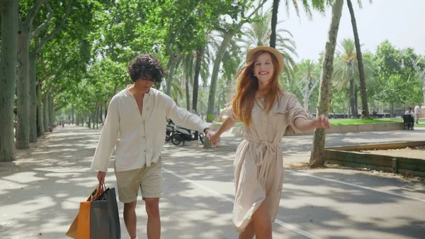 Couple touristique marchant avec des sacs à provisions en plein air. Jeune famille tenant la main — Photo