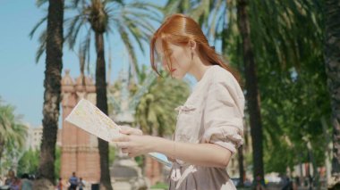 Kapalı kapılar ardında gezen turist kadın haritaya bakıyor. Kadın turist yön arıyor.