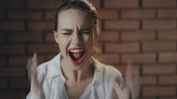 Nervöse Frau schreit und flucht im Studio. Porträt wütendes Mädchen winkt — Stockfoto