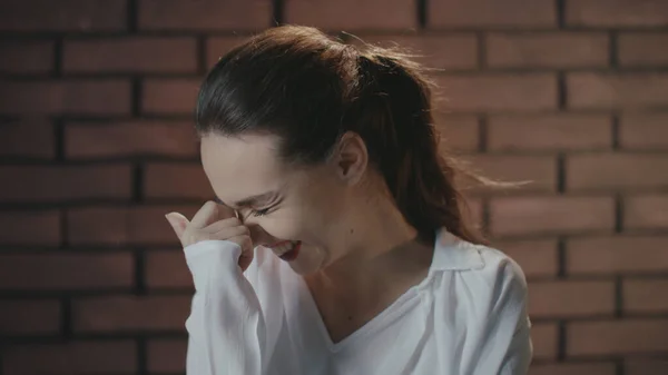 Mujer bonita riendo y escondiendo sonrisa con las manos mientras filma vídeo en el estudio — Foto de Stock