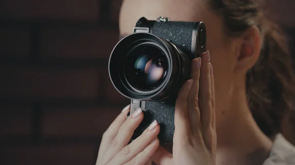 Piękna kobieta używająca retro aparatu fotograficznego. Dziewczyna fotograf pracuje w studio — Zdjęcie stockowe