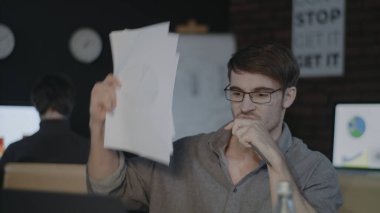 Kızgın iş adamı ofisteki masaüstü bilgisayarına evrak fırlatıyor.