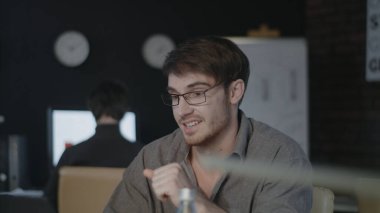Neşeli iş adamı karanlık ofiste görüntülü sohbet ile konuşuyor..