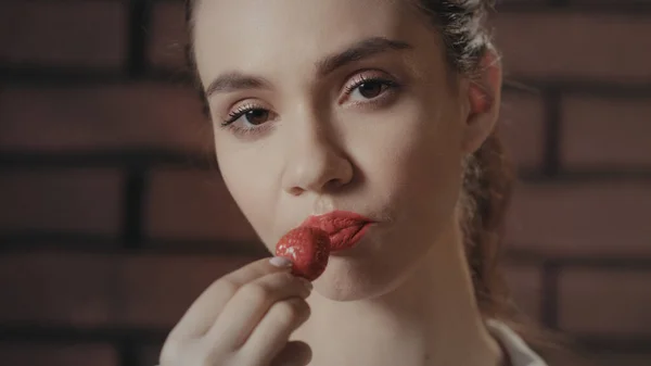 Mujer sexy comiendo fresas maduras en cámara. Chica sensual comiendo fresa — Foto de Stock