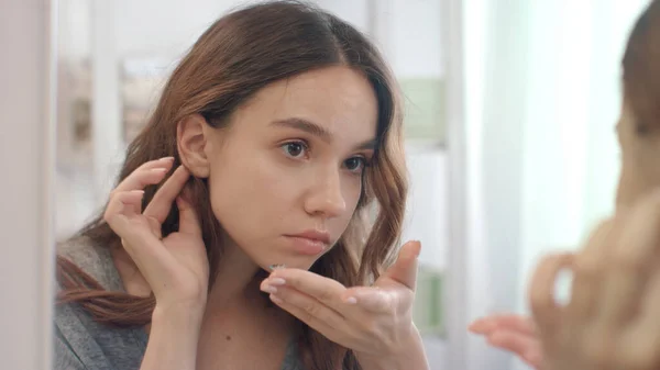 Focused woman putting on contact lenses in eye front bathroom mirror — Stock Photo, Image