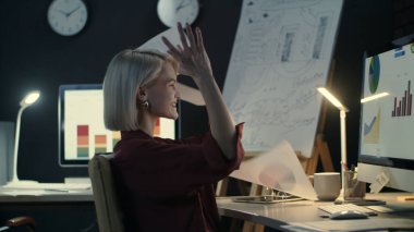 Mutlu iş kadını gece ofisine döküman atıyor..