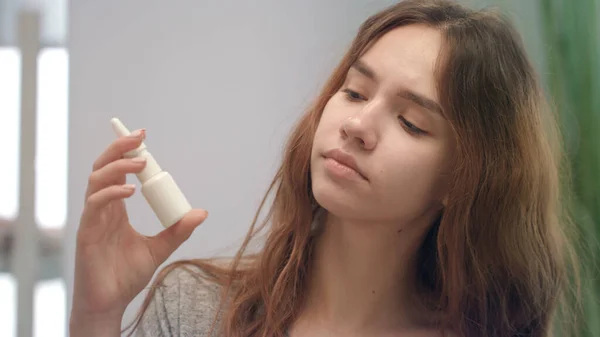 Young woman feeling blocked nose while allergy and spraying nasal spray — Stock Photo, Image
