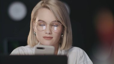 Gece ofisinde cep telefonu kullanan güzel bir iş kadını..