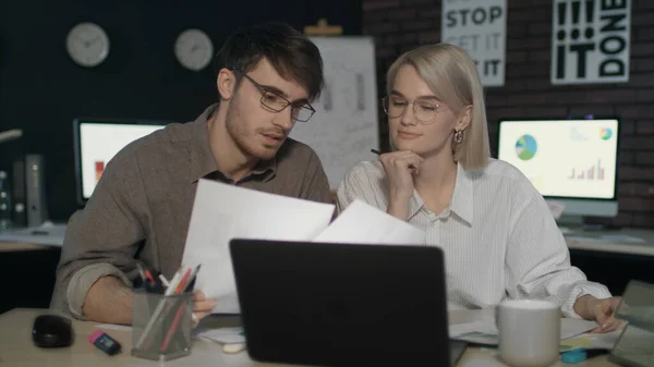 Επαγγελματικό ζευγάρι που εργάζονται μαζί με τα στοιχεία έγγραφο μπροστά φορητό υπολογιστή στο γραφείο νύχτα — Φωτογραφία Αρχείου