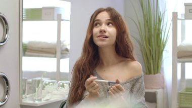 Endişeli kadın sabah banyoda hamilelik testinin sonucunu bekliyor.