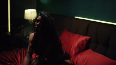 Yatakta ipek çarşaf sıkan şehvetli bir kız. Dantel iç çamaşırlarıyla poz veren muhteşem bir kadın.