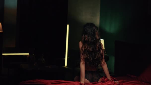 Donna lingerie sconosciuta seduta lenzuola di seta rossa. Ragazza snella lanciando indietro la testa. — Video Stock