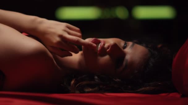 Verführerisches Mädchen, das Lippen im Bett berührt. Heiße Dame umarmt sich auf Seidentüchern — Stockvideo