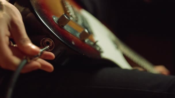 Αγνώριστο άτομο που συνδέει την πρίζα με την ηλεκτρική κιθάρα στο στούντιο ηχογράφησης. — Αρχείο Βίντεο