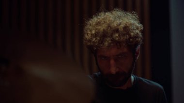 Rock müzisyeni stüdyoda müzik yapıyor. Davulcu, konser salonunda başını sallıyor..