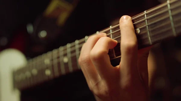 Гітарист грає на акустичній гітарі в студії. Репетиція музикантів у приміщенні . — стокове фото