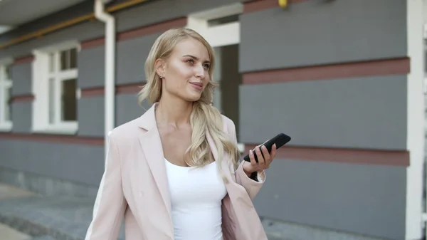 Leende kvinna sms: ar på mobilen. Kvinna surfa internet på telefon — Stockfoto