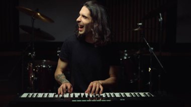 İçeride rock çalan etkileyici bir adam. Neşeli adam müzik stüdyosunda eğleniyor..