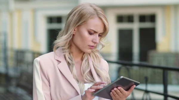 Acercamiento mujer molesta trabajando en touchpad fuera. Persona que usa tableta al aire libre —  Fotos de Stock