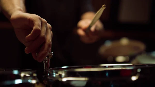 Невпізнаваний музикант настроює барабанний набір у студії. Барабанщик вдарив барабан у залі . — стокове фото