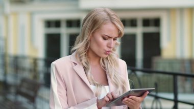 Sokakta tablet bilgisayar kullanan bir kadın. Touchpad 'de çalışan iş kadını