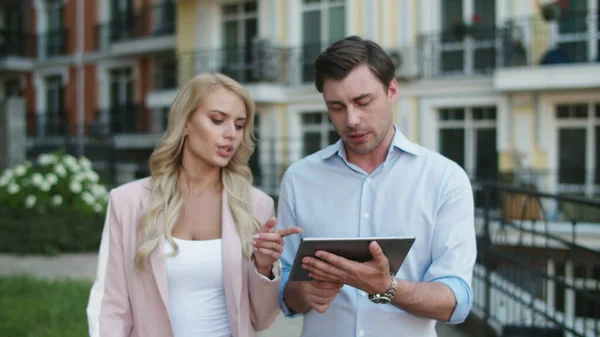 Επιχειρηματίες που χρησιμοποιούν τον υπολογιστή tablet στο δρόμο. Επαγγελματικό ζευγάρι περπατά μαζί — Φωτογραφία Αρχείου