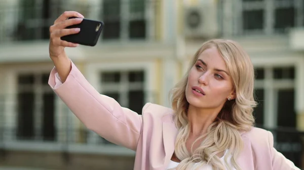 Porträtgirl macht Selfie auf der Straße. Geschäftsfrau fotografiert im rosa Anzug — Stockfoto