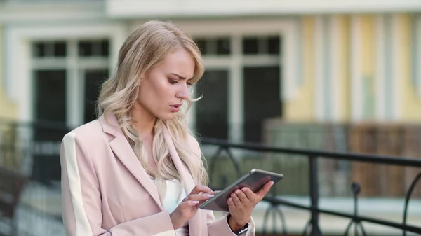 Een close-up vrouw die slecht nieuws krijgt op touchpad. Vrouw werkt op tablet op straat — Stockfoto