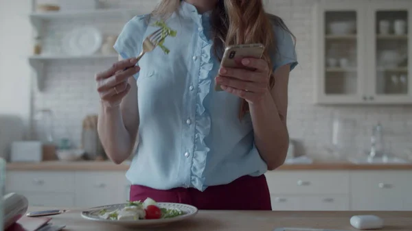 Närbild affärskvinna som äter lunch i modernt kök. Flickätande sallad. — Stockfoto