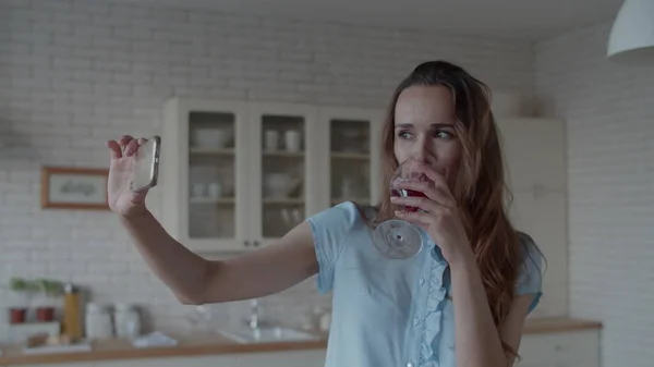 Ung kvinna poserar för foto med glas rött vin. Flicka gör selfie foto. — Stockfoto