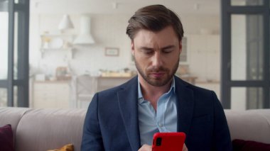 İş adamı ofisteki cep telefonuyla rahatlıyor. Akıllı telefondan konuşan adam..