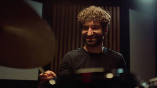 Усміхнений барабанщик розважається в студії. Музикант грає на барабанних цимбалах в приміщенні . — стокове фото
