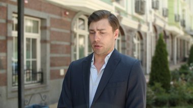 Kapanış adamı caddede ortağını bekliyor. Akıllı saati kontrol eden adam