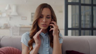 Ofiste telefonla konuşan üzgün bir kadın. Hoş olmayan telefon görüşmesi..