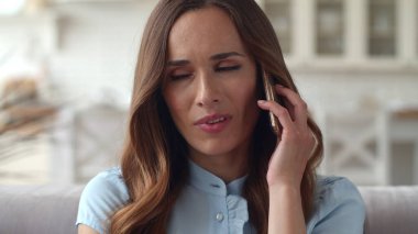 Endişeli iş kadını evde ağır çekimde cep telefonuyla konuşuyor..