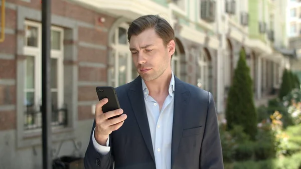 Retrato homem usando smartphone ao ar livre. Empresário digitando no telefone na rua — Fotografia de Stock