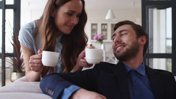 Χαμογελώντας ζευγάρι πίνοντας τσάι στο σπίτι μαζί. Χαρούμενο ζευγάρι που κάνει διάλειμμα για καφέ. — Φωτογραφία Αρχείου